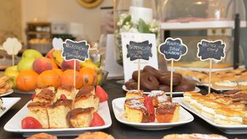 A buffet with various desserts and fruits.