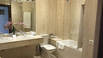A bathroom with two sinks, a toilet, and a bathtub.