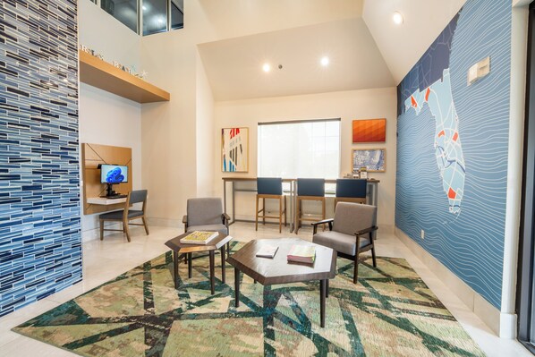A modern living room with a large window, a coffee table, and a seating area.