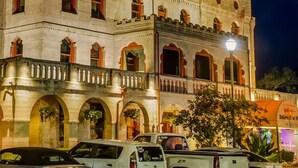 A historic building with arched windows and a balcony, featuring a flag on top. - Holiday Inn Express St. Augustine near Dtwn - Historic by IHG (St. Augustine)