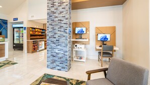 A lobby with a seating area, a snack bar, and a reception desk. - Holiday Inn Express St. Augustine near Dtwn - Historic by IHG (St. Augustine)