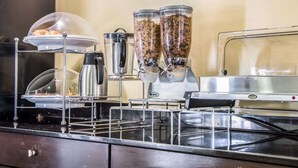A buffet setup with a coffee machine, a food dispenser, and a glass container with food items. - Sleep Inn Tinley Park I-80 near Amphitheatre-Convention Center (Tinley Park)