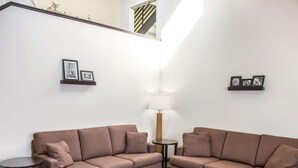 A living room with two sofas, a coffee table, and a lamp. There are picture frames on the walls. - Sleep Inn Tinley Park I-80 near Amphitheatre-Convention Center (Tinley Park)