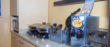 A kitchen with waffle makers, a waffle iron, and a waffle machine.