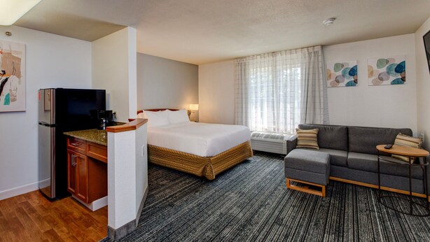 Ein Hotelzimmer mit Bett, Sofa, Schreibtisch und Fernseher.