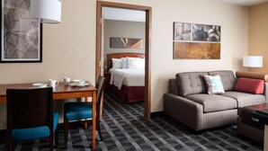 A hotel room with a bed, a sofa, a desk with chairs, and artwork on the walls. - Sonesta Simply Suites Seattle Renton (Renton)