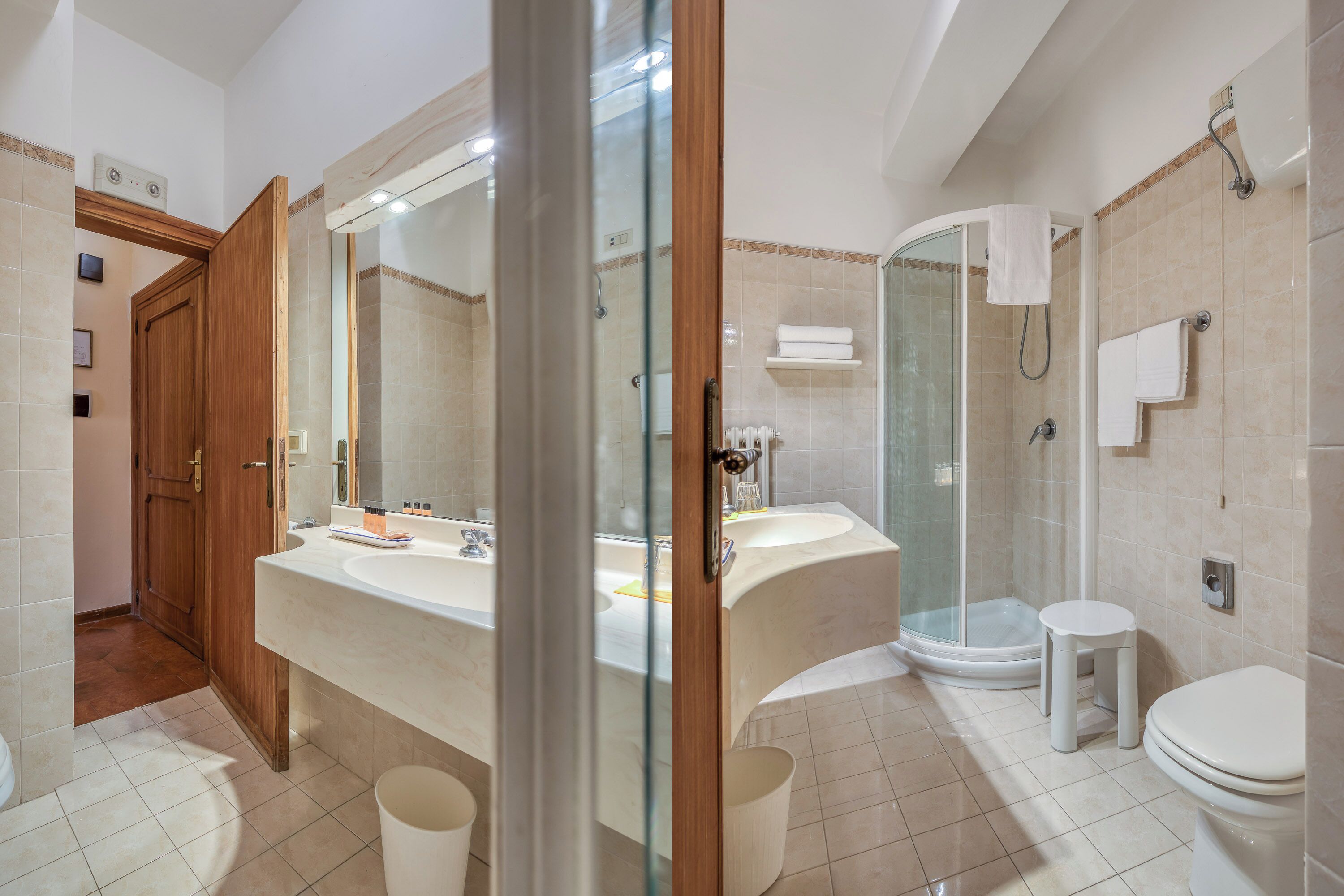 Une salle de bain moderne dotée d’une douche à parois de verre, d’un grand miroir et d’un meuble-lavabo avec un évier et un plan de travail.
