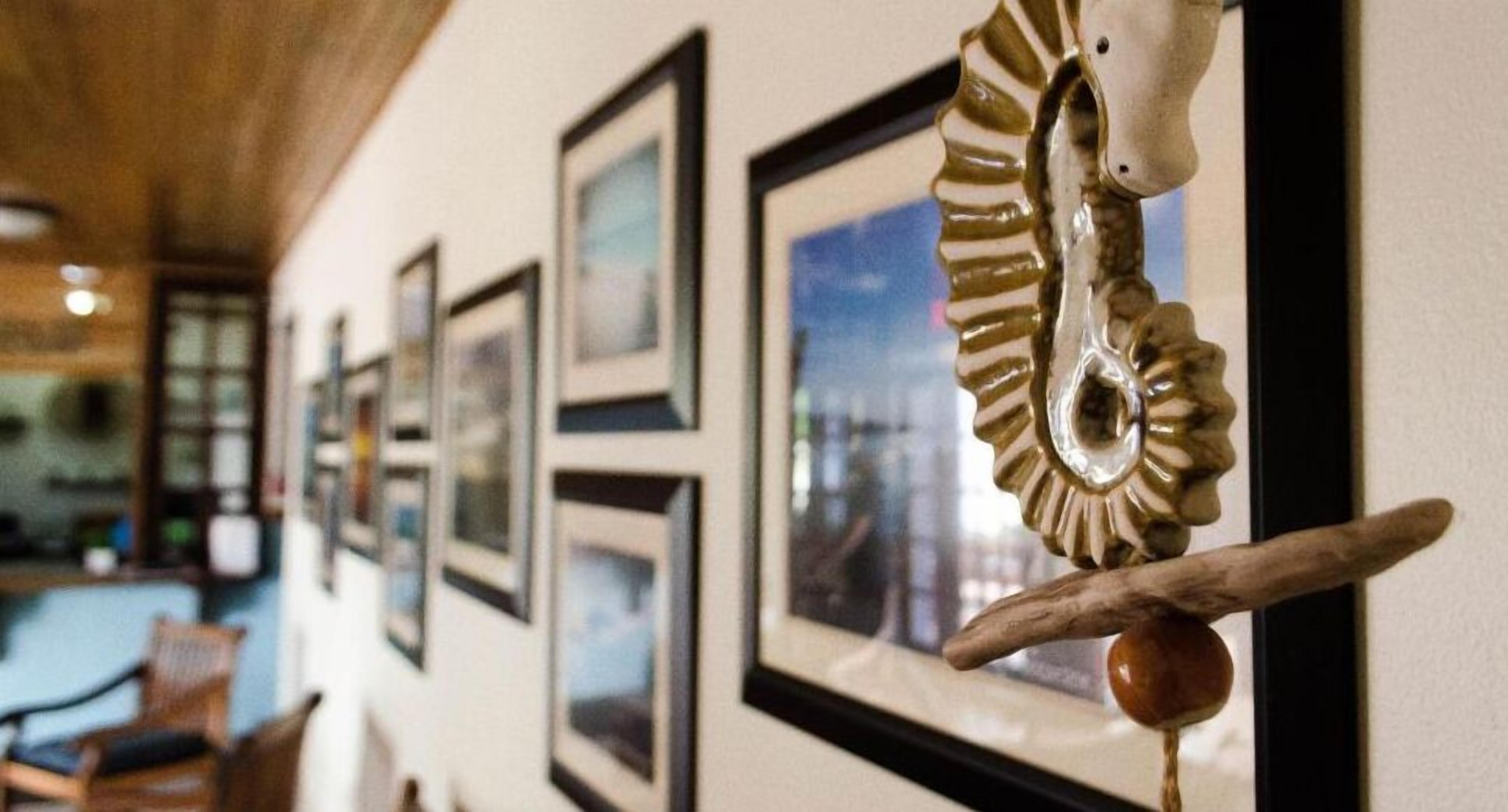 A wall with framed pictures and a decorative hanging ornament.
