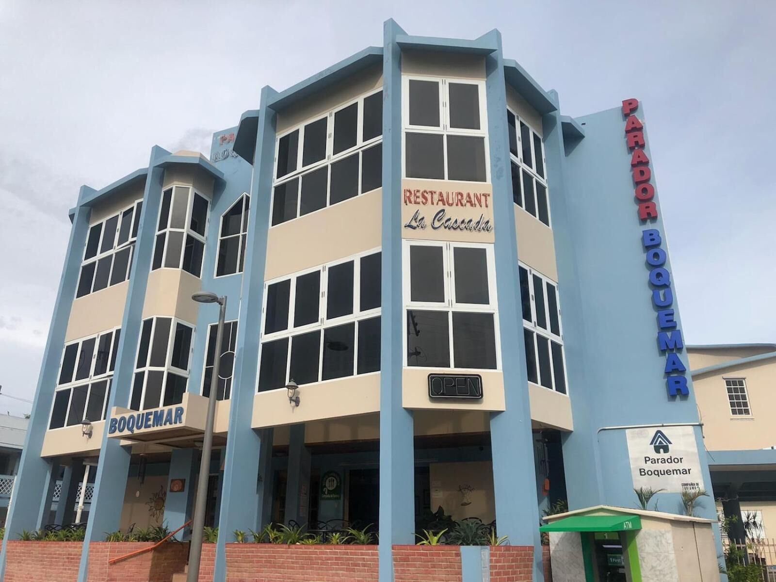 A building with a 'BOQUEMAR' sign, a 'PARADOR BOQUEMAR' sign, and a 'RESTAURANT La Cascada' sign.