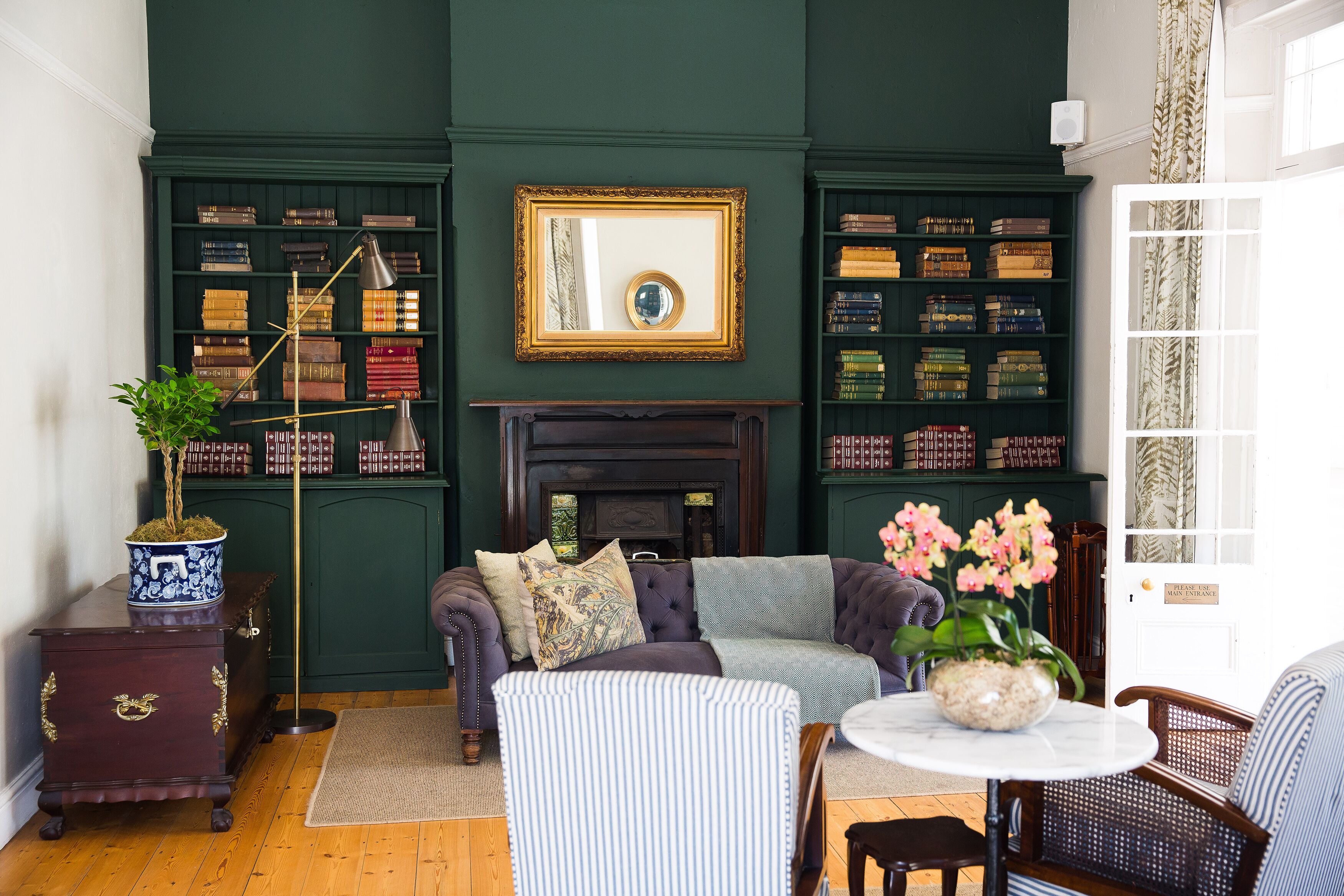 A cozy living room with a fireplace, bookshelves, and comfortable seating.
