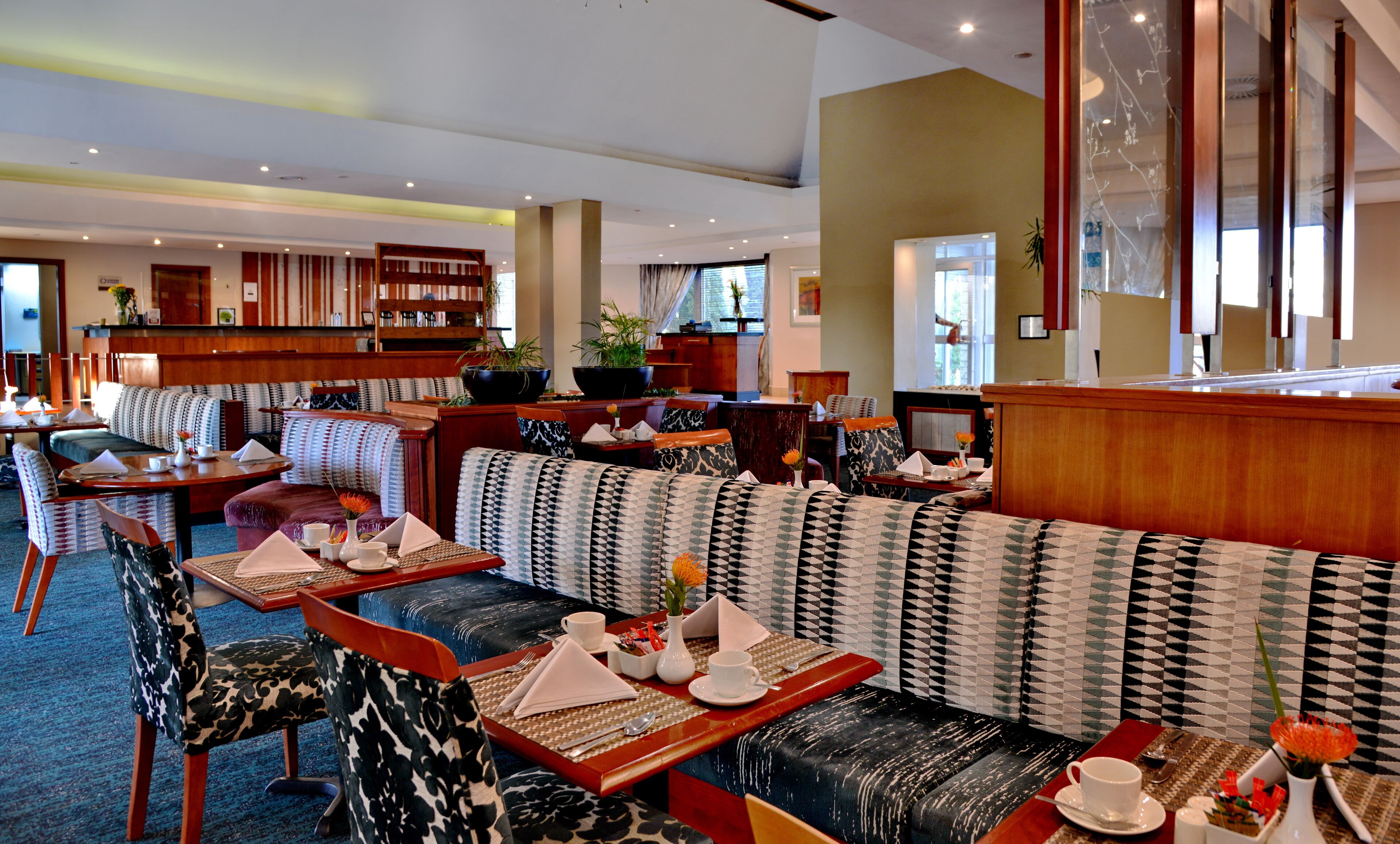 A restaurant with booths and tables, wooden furniture, and a bar area.