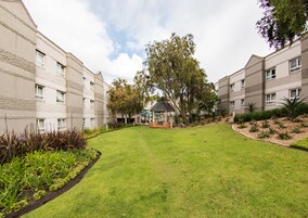 A courtyard with a gazebo, surrounded by multi-story buildings with uniform architecture.