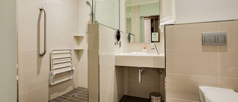 A modern bathroom with a shower, toilet, and sink.