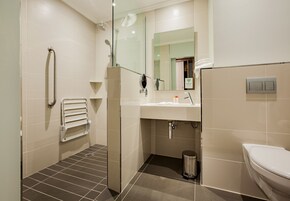 A modern bathroom with a shower, toilet, and sink.