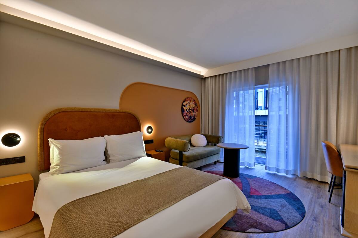 Ein Hotelzimmer mit einem großen Bett, einer Couch, einem kleinen Tisch und einem Sessel.