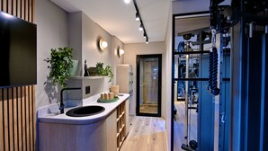 Une cuisine moderne dotée d’un évier encastré, de meubles en bois et d’un plan de travail agrémenté d’une plante et d’un panier.