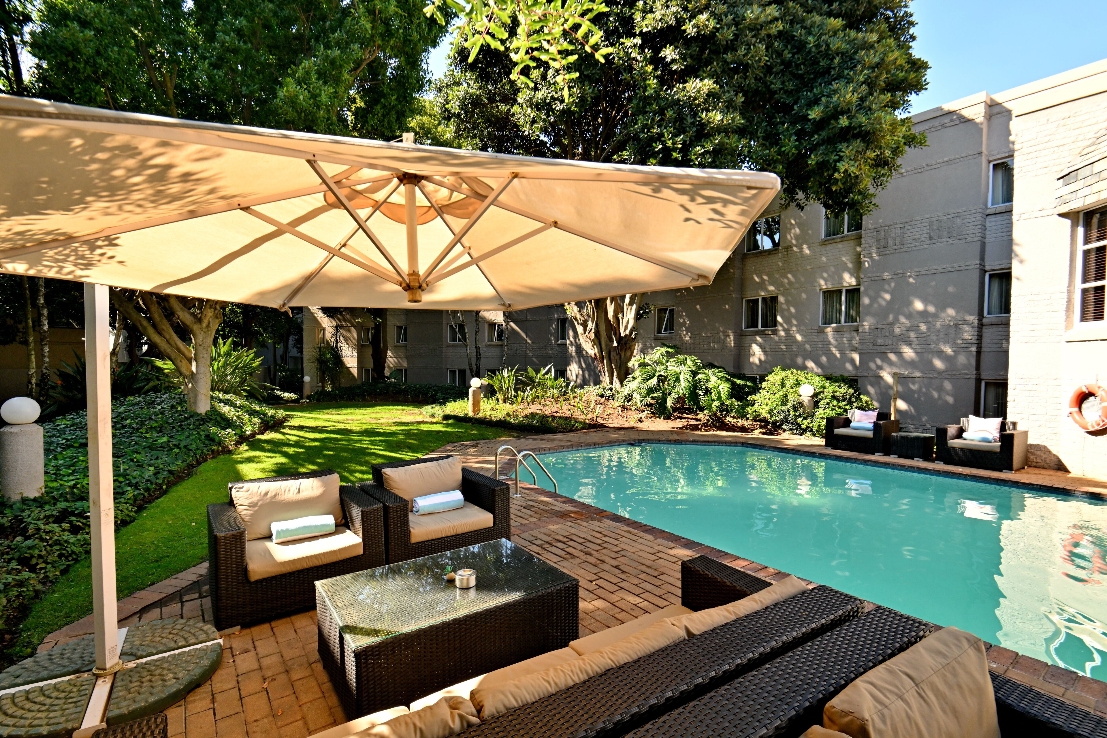 Una piscina al aire libre, sillones reclinables de piscina