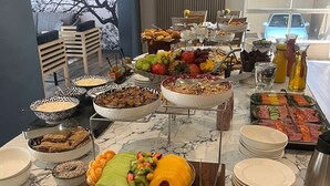 A buffet with various fruits, pastries, and beverages. - Courtyard Hotel Sandton (Sandton)