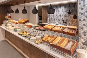 Un bufé con diferentes opciones de comida y una estación de café.