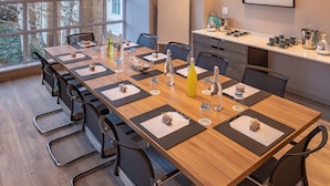 A conference room with a long table, chairs, a whiteboard, and a window with a view of trees. - Town Lodge Johannesburg Airport (Kempton Park)