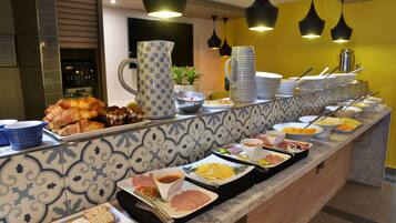 Un bufé con diversos alimentos y utensilios para servir.