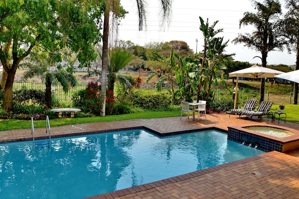 Una piscina al aire libre, sillones reclinables de piscina