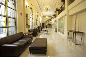 A spacious lobby with a long reception desk, leather seating, and a chandelier. - Best Western Centro Monterrey (Monterrey)