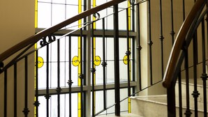 A staircase with a wrought iron railing leading to a room with a large stained glass window. - Best Western Centro Monterrey (Monterrey)