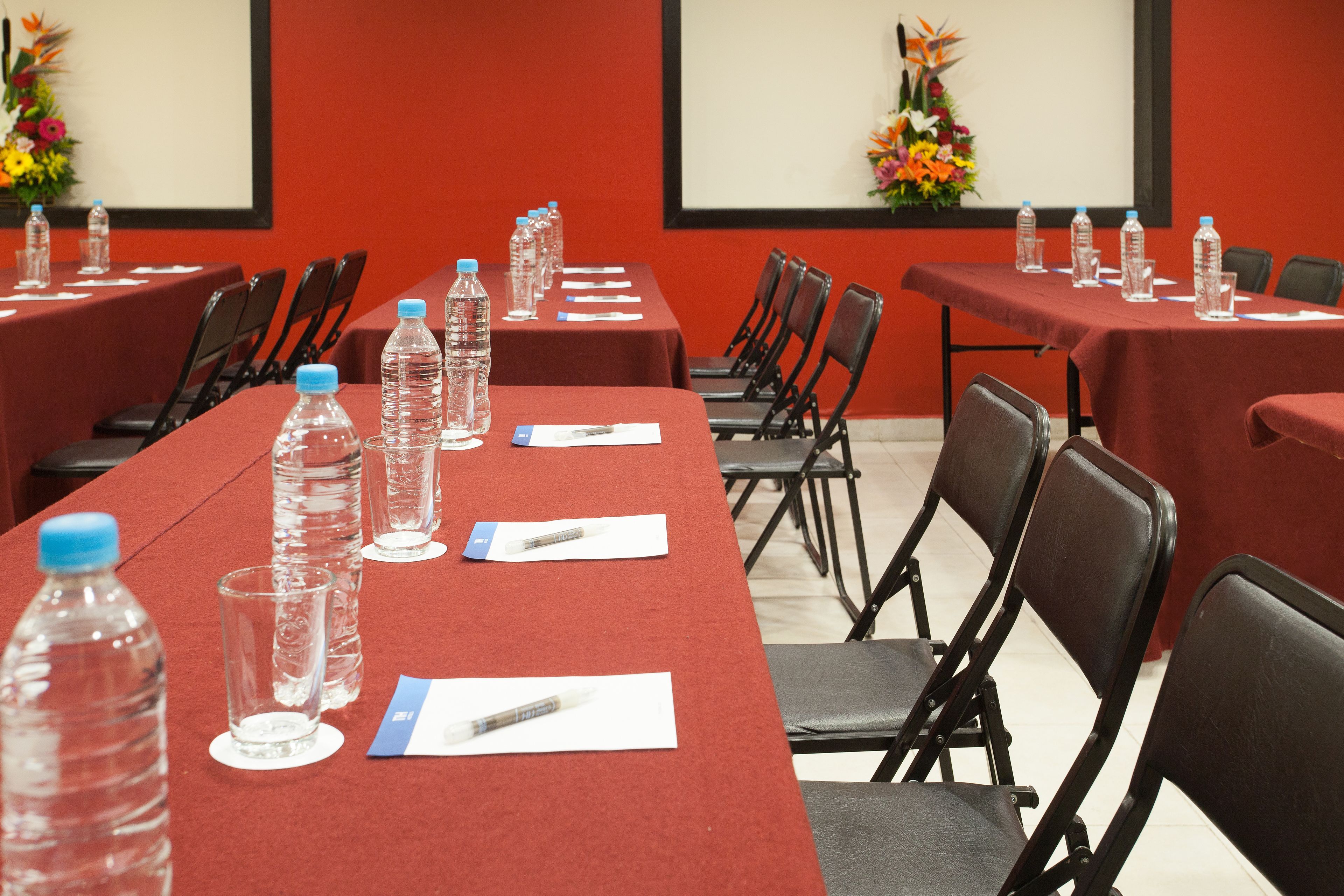 A conference room with long tables, chairs, water bottles, and name cards.