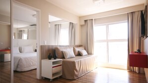 Een moderne hotelkamer met een bed, nachtkastje en een grote spiegel.