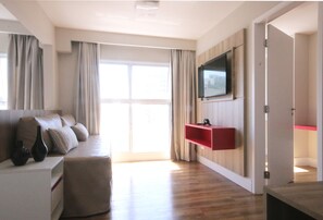 Un salon moderne avec un canapé, un téléviseur à écran plat fixé au mur et un plancher en bois.