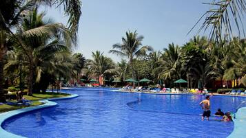 Relax by the serene pool surrounded by lush palm trees and comfortable lounge chairs.
