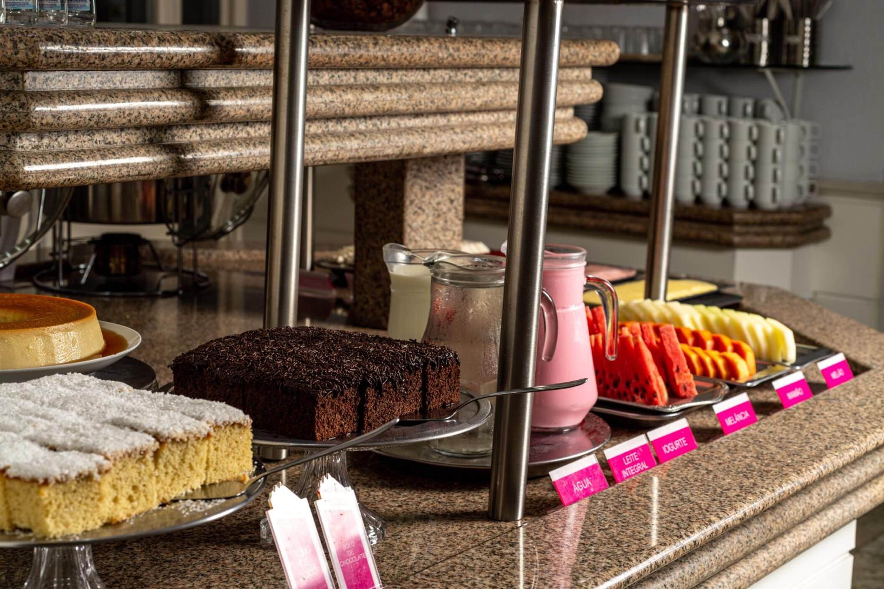 A dessert display with various cakes and pastries, including a chocolate cake and a white frosted cake.