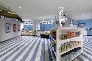 A modern interior with a striped floor, a display counter with various products, and framed artwork on the walls.