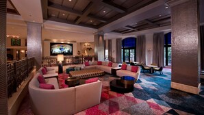 A spacious lobby with a large sectional sofa, a flat-screen TV, and a bar area. - Universal's Hard Rock Hotel (Orlando)