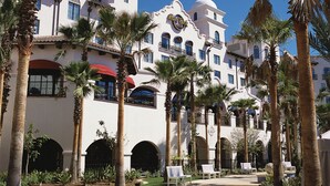 A hotel with a white facade, multiple balconies, and palm trees. - Universal's Hard Rock Hotel (Orlando)