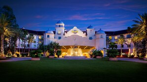 A large, white building with multiple domes and a fountain in the center, surrounded by palm trees and well-lit pathways. - Universal's Hard Rock Hotel (Orlando)
