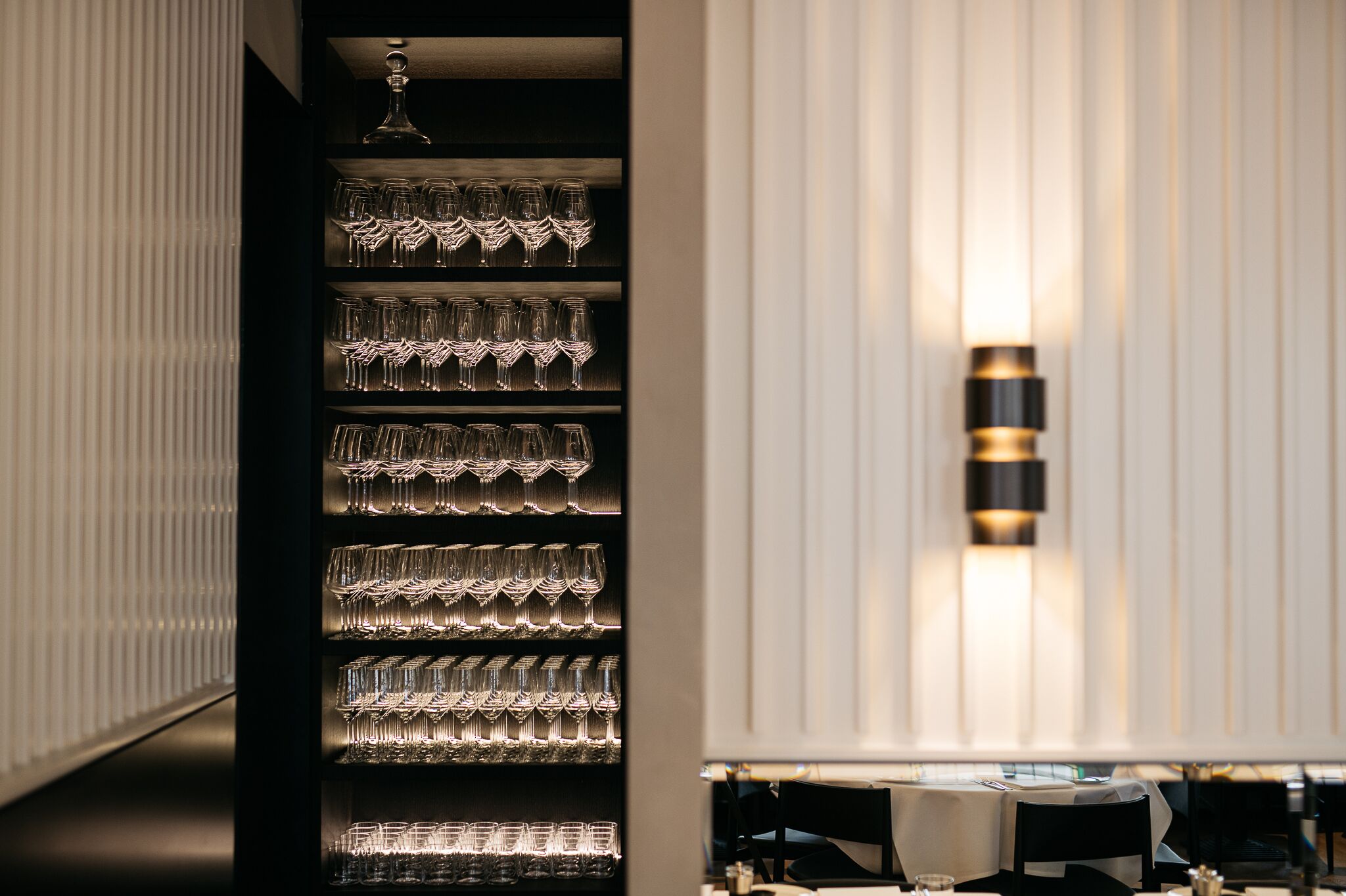 A neatly organized wine rack with multiple shelves of wine glasses.
