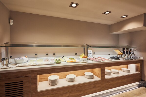 A buffet setup with various food items and utensils. - Hotel Silken Sant Gervasi (Barcelona)