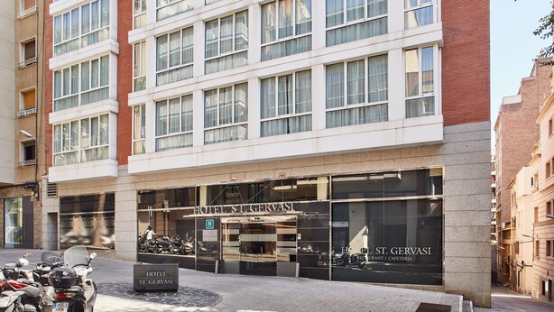 Un hotel de varios pisos con fachada moderna, ventanas grandes y un letrero que indica que es el Hotel St. Gervasi.