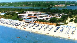 A coastal hotel with a large beach area, multiple swimming pools, and a view of the surrounding landscape. - Hotel Le Dune (Sabaudia)