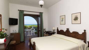 Ein Schlafzimmer mit Bett, Schreibtisch, Stuhl, Fernseher und einem Balkon mit Blick.