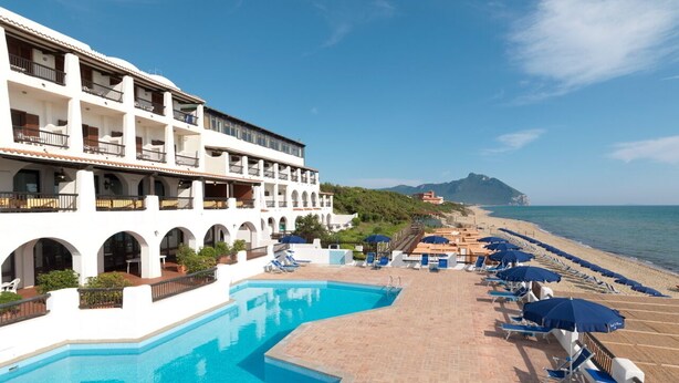 A resort with a swimming pool, beachside lounge chairs, and a view of the sea. - Hotel Le Dune (Sabaudia)