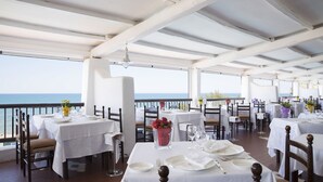 A restaurant with tables set for dining, overlooking the sea. - Hotel Le Dune (Sabaudia)