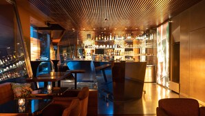 A modern bar area with wooden ceiling, bar stools, and a variety of bottles and glasses. - The Hotel Luzern, Autograph Collection (Lucerne)