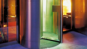 A modern elevator with a metallic exterior and a glass door, located in a building with a contemporary design. - The Hotel Luzern, Autograph Collection (Lucerne)