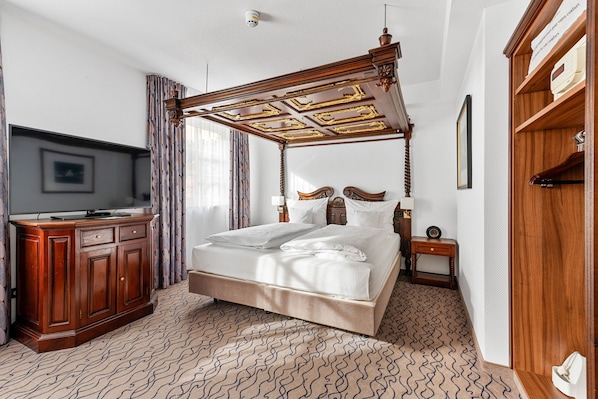 Un dormitorio con una cama con dosel, un aparador de madera, un televisor y un armario.