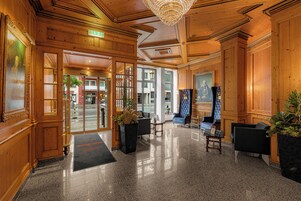 Una hall con pannelli in legno, un lampadario e zone relax.