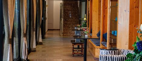 Vestíbulo de hotel con escalera, mostrador de recepción y zonas de estar.