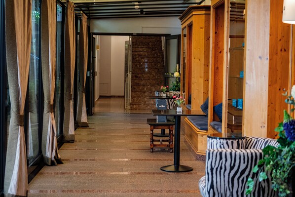 Vestíbulo de hotel con escalera, mostrador de recepción y zonas de estar.